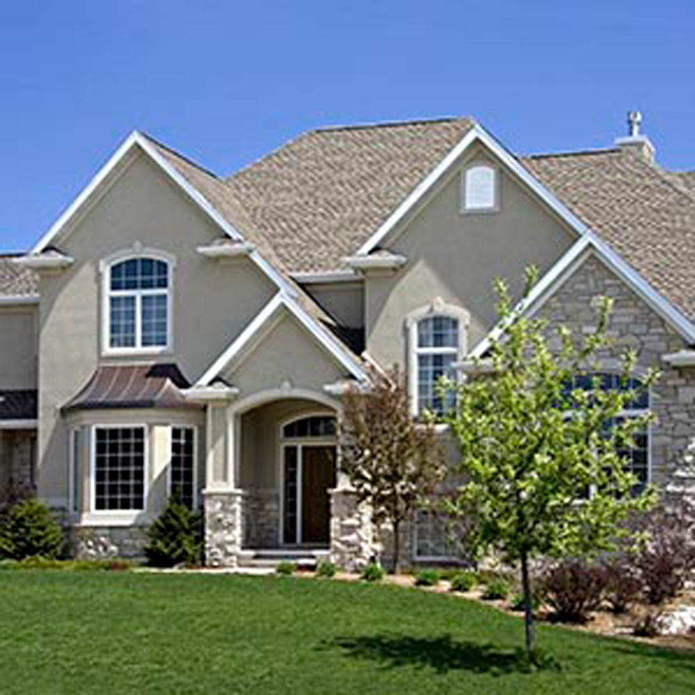 A beautiful tan house with stucco siding installed by Precision Siding and Windows in Kansas City